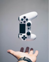 A hand holding a floating game controller